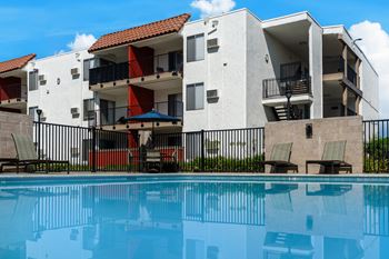 a large swimming pool in front of an apartment building